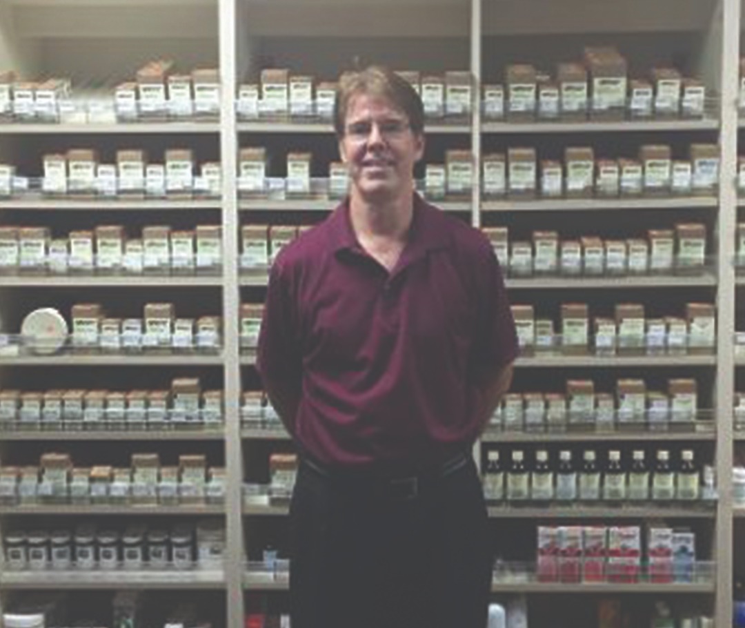 Dr. Ruckel standing in front of his supplement sales display.