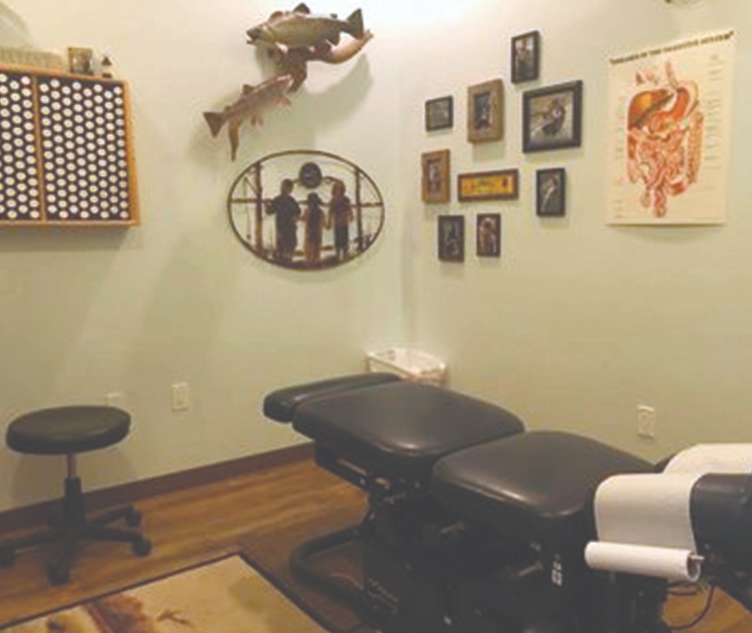 Exam room with chiropractic table with fish on the walls